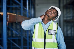 young man experiencing neck pain while working at a construction site