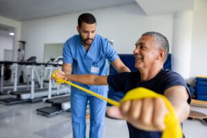 Man doing physical therapy exercises using a stretch band for spine health