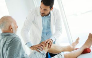 Senior man having his knee examined by a doctor for knee arthritis